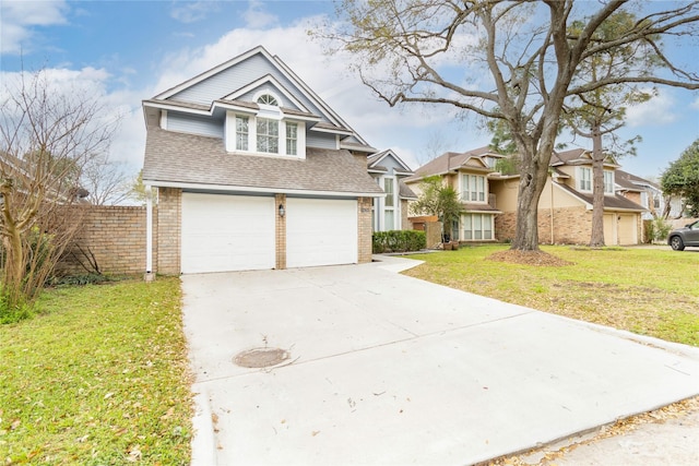 view of front facade featuring brick siding, driveway, a shingled roof, and a front yard