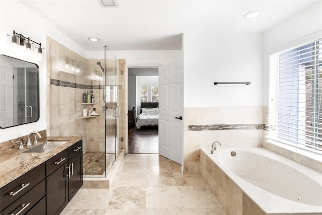 ensuite bathroom with ensuite bath, a shower stall, vanity, and a whirlpool tub