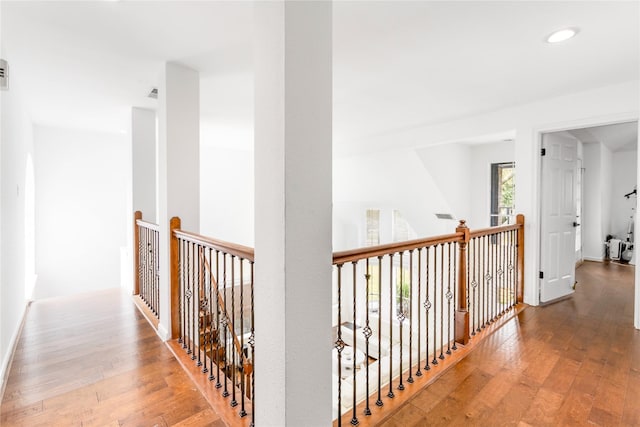 hall with recessed lighting, baseboards, an upstairs landing, and hardwood / wood-style floors