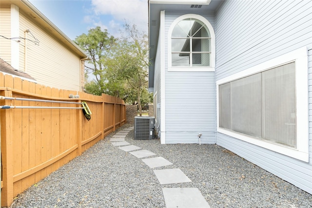 view of home's exterior featuring central AC unit and fence