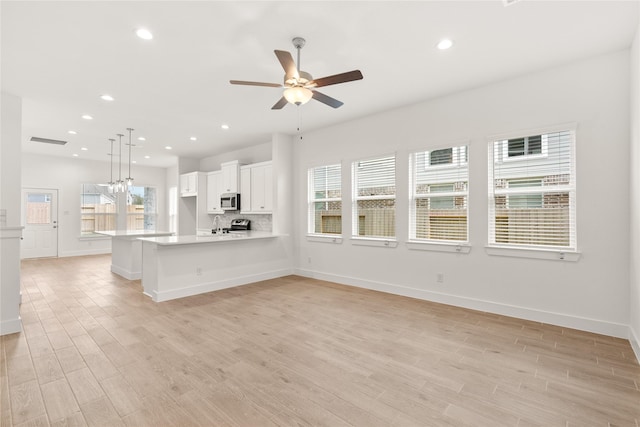 kitchen featuring light countertops, plenty of natural light, light wood-type flooring, and stainless steel appliances