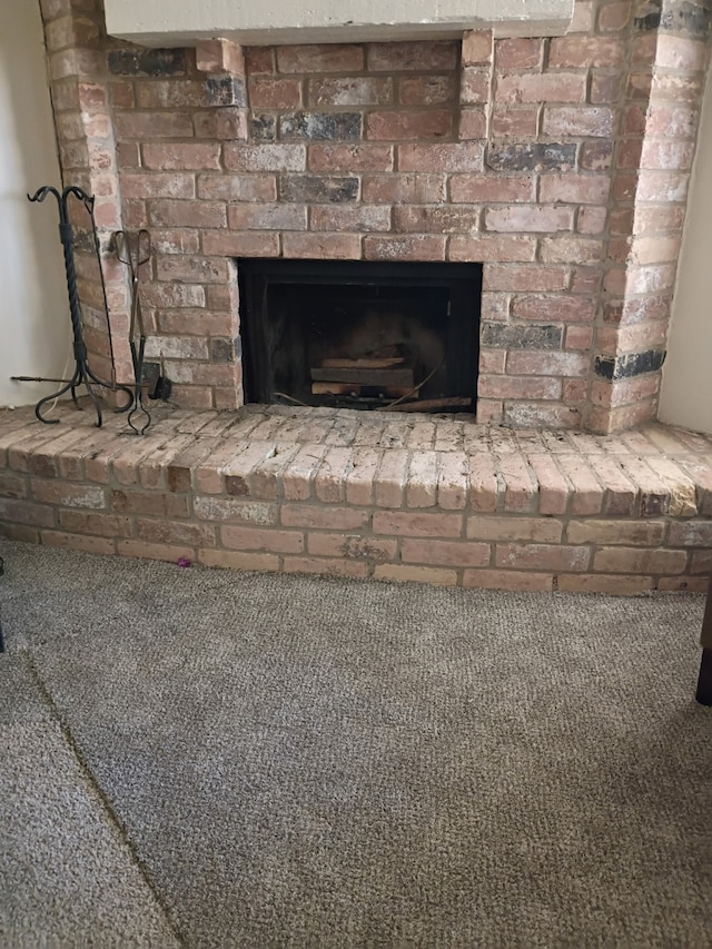 interior details with carpet floors and a brick fireplace