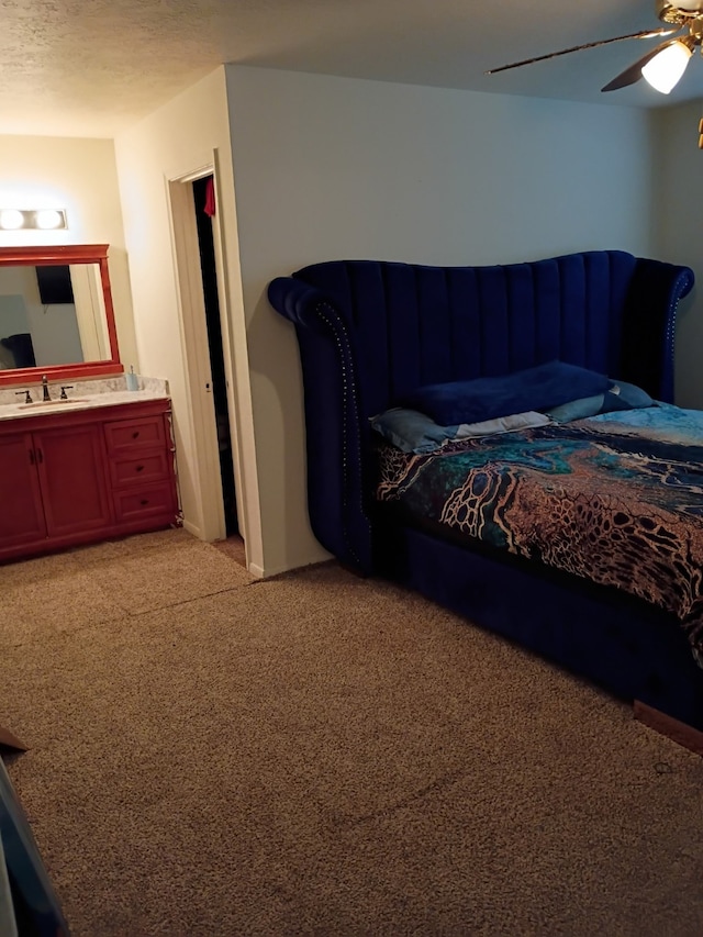 bedroom featuring light colored carpet, a textured ceiling, a ceiling fan, and a sink