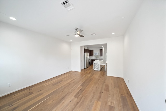 unfurnished living room with light wood finished floors, visible vents, baseboards, recessed lighting, and a ceiling fan