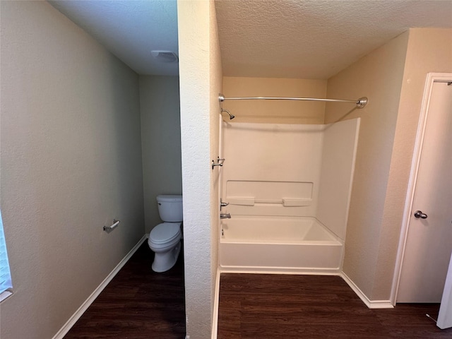 bathroom featuring baseboards, toilet, wood finished floors, and a textured ceiling