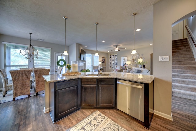 kitchen with light stone countertops, a sink, dark brown cabinets, stainless steel dishwasher, and open floor plan