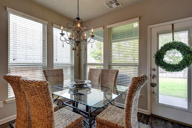 dining room with a notable chandelier, visible vents, a wealth of natural light, and wood finished floors