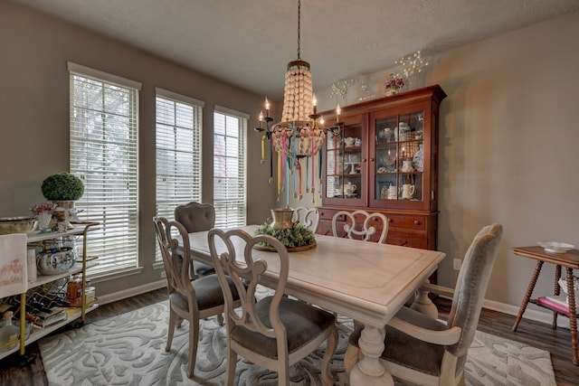 dining area featuring a notable chandelier, wood finished floors, and baseboards