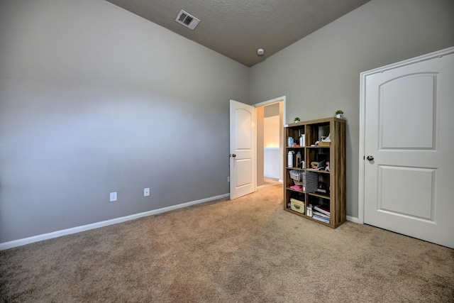 unfurnished bedroom featuring baseboards, visible vents, carpet floors, and a textured ceiling