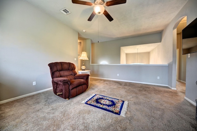 living area with a ceiling fan, carpet, visible vents, baseboards, and arched walkways