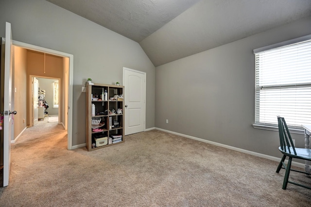 office space with baseboards, lofted ceiling, carpet, and attic access