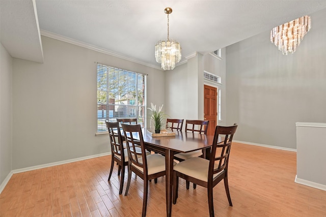 dining space with light wood-type flooring, baseboards, and a chandelier