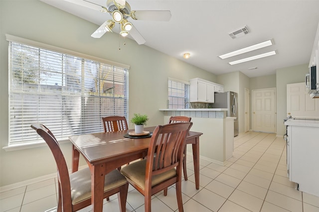 dining area with light tile patterned floors, visible vents, and plenty of natural light