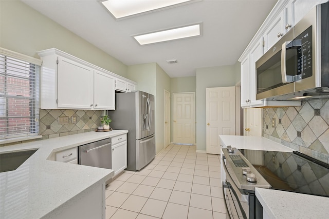 kitchen featuring visible vents, backsplash, white cabinetry, appliances with stainless steel finishes, and light tile patterned floors