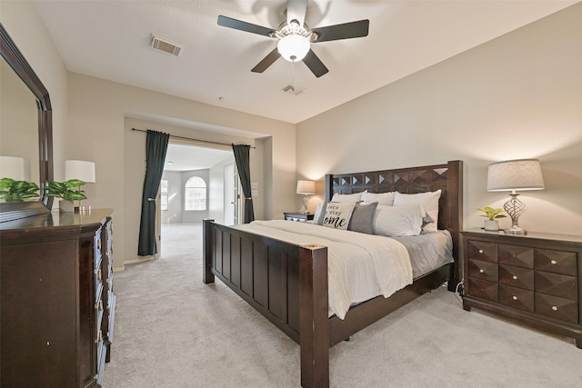 bedroom with visible vents, light colored carpet, and ceiling fan