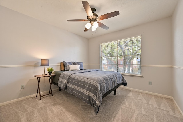 carpeted bedroom with a ceiling fan and baseboards