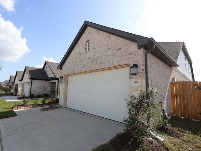 8035 Kay Harbor Dr, Cypress, TX 77433 - view of side of home with driveway, a garage, brick siding, stone siding, and a shingled roof