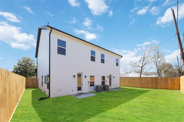 back of property featuring a lawn, central AC unit, and a fenced backyard