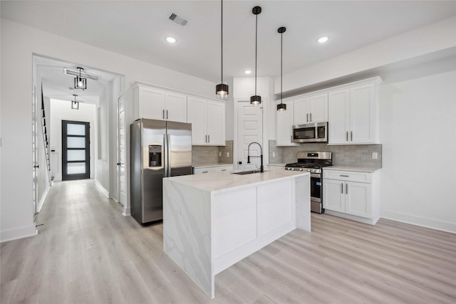 kitchen with visible vents, white cabinets, appliances with stainless steel finishes, and a sink