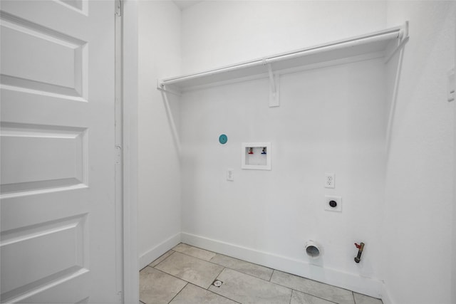 clothes washing area with baseboards, light tile patterned floors, hookup for a washing machine, hookup for a gas dryer, and hookup for an electric dryer