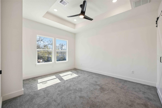 carpeted empty room with recessed lighting, visible vents, a raised ceiling, and baseboards