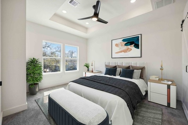 bedroom featuring recessed lighting, visible vents, a raised ceiling, and dark carpet