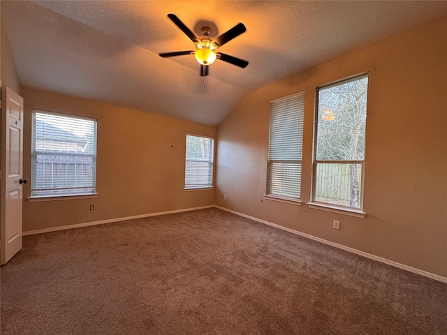 carpeted empty room with baseboards, a textured ceiling, a ceiling fan, and vaulted ceiling