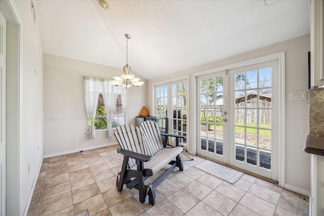 sitting room with light tile patterned floors, lofted ceiling, french doors, a textured ceiling, and a chandelier