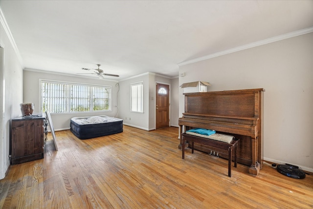 bedroom featuring light wood-type flooring, baseboards, ceiling fan, and crown molding