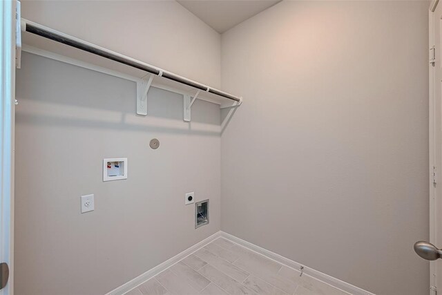 clothes washing area featuring baseboards, gas dryer hookup, hookup for an electric dryer, laundry area, and washer hookup