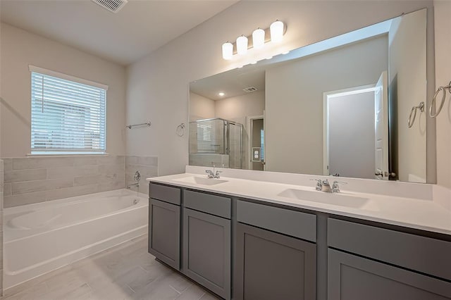 full bath with double vanity, a bath, a stall shower, and a sink