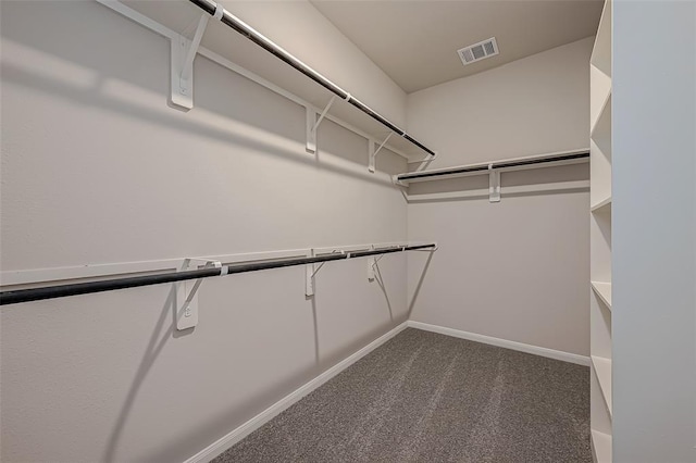 walk in closet with visible vents and dark colored carpet