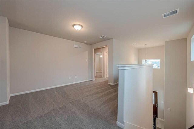 empty room with visible vents, baseboards, and carpet floors