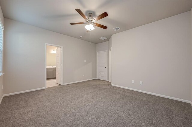 unfurnished bedroom with visible vents, baseboards, light colored carpet, and ensuite bathroom