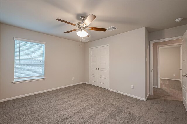 unfurnished bedroom featuring carpet flooring, baseboards, visible vents, and a closet