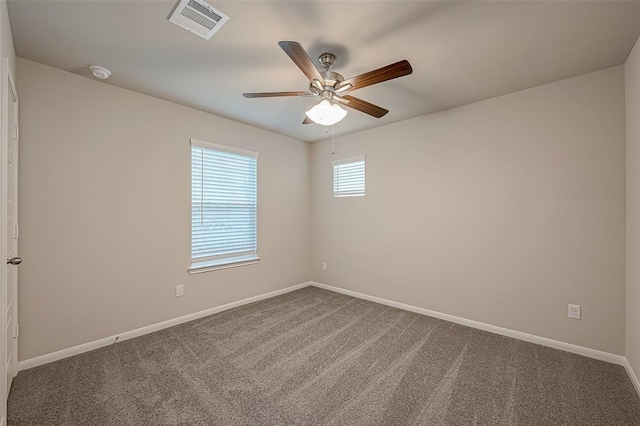 carpeted spare room featuring visible vents, baseboards, and a ceiling fan