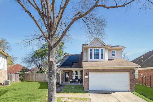 traditional home with a front lawn, fence, concrete driveway, brick siding, and solar panels