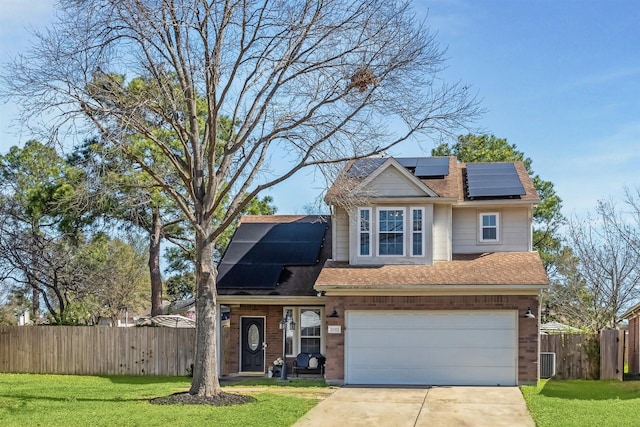 traditional home featuring solar panels, a front yard, fence, and driveway