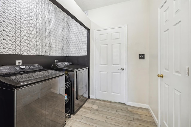 washroom with laundry area, baseboards, wood tiled floor, and separate washer and dryer