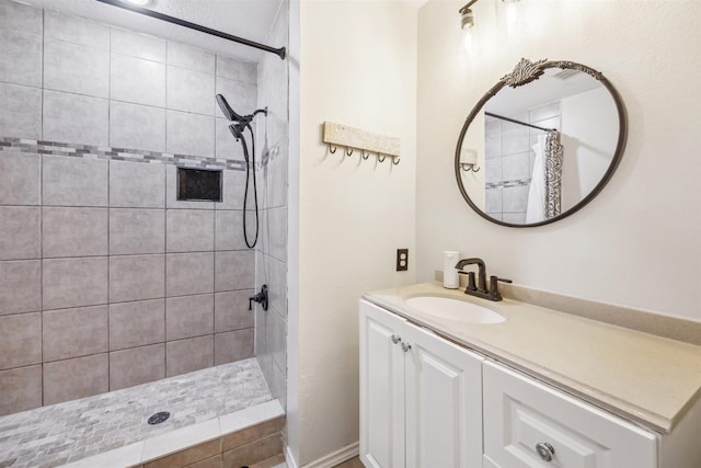 full bathroom featuring vanity and tiled shower