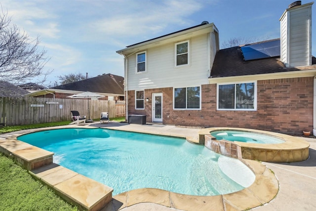 view of swimming pool featuring a pool with connected hot tub, a fenced backyard, and a patio area