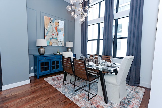 dining room with a notable chandelier, wood finished floors, and baseboards