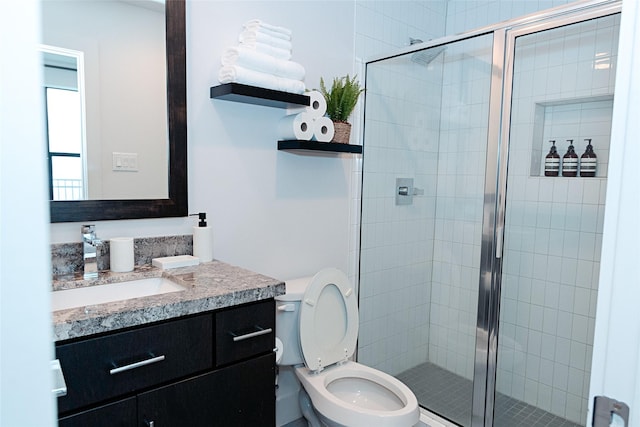 full bath with vanity, a shower stall, and toilet