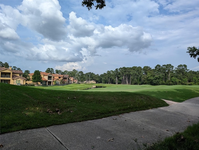 view of home's community featuring view of golf course and a lawn