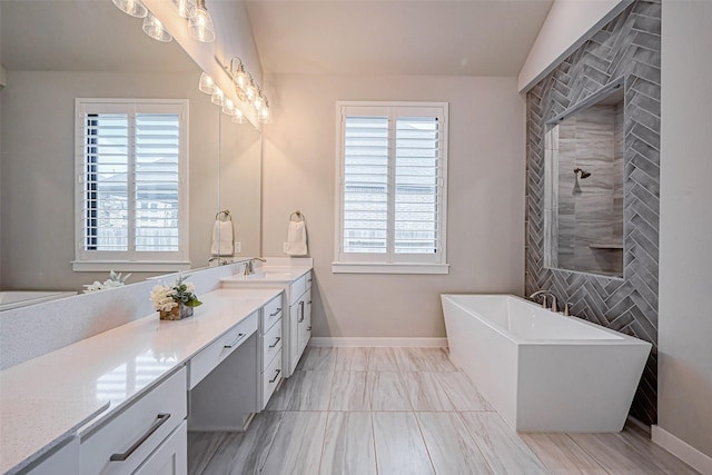 bathroom featuring vanity, a freestanding tub, a wealth of natural light, and tiled shower