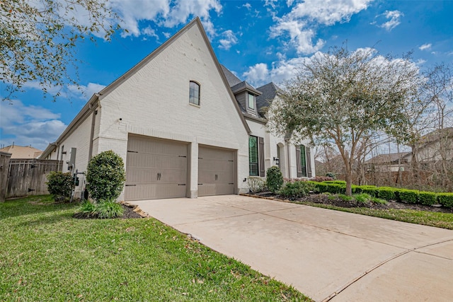 view of home's exterior featuring brick siding, fence, concrete driveway, a yard, and a garage