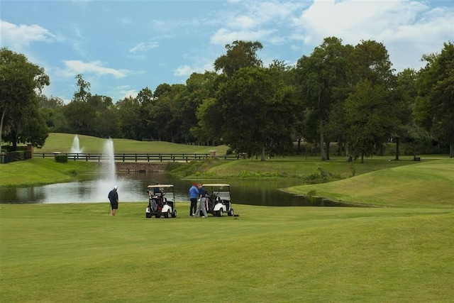 surrounding community featuring a lawn and a water view