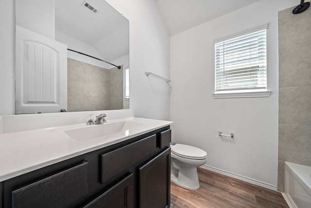 full bathroom with vanity, wood finished floors, visible vents, vaulted ceiling, and toilet