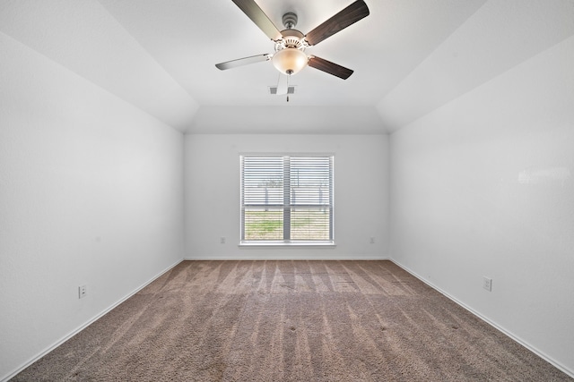 carpeted spare room with vaulted ceiling, baseboards, visible vents, and ceiling fan