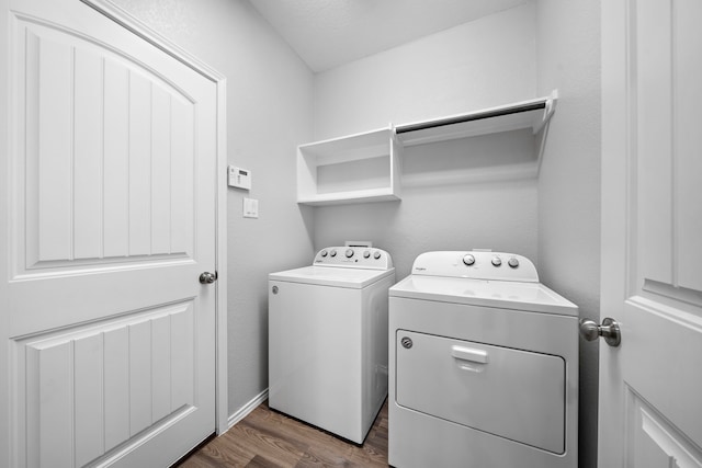 washroom featuring washer and dryer, laundry area, and dark wood-style floors